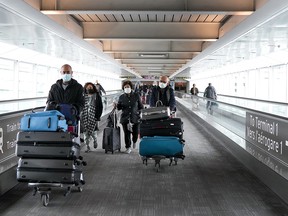 People travel at Pearson International Airport in Toronto, Friday, Dec. 3, 2021. New travel testing and restrictions have been put in place due to the newly discovered Omicron variant.