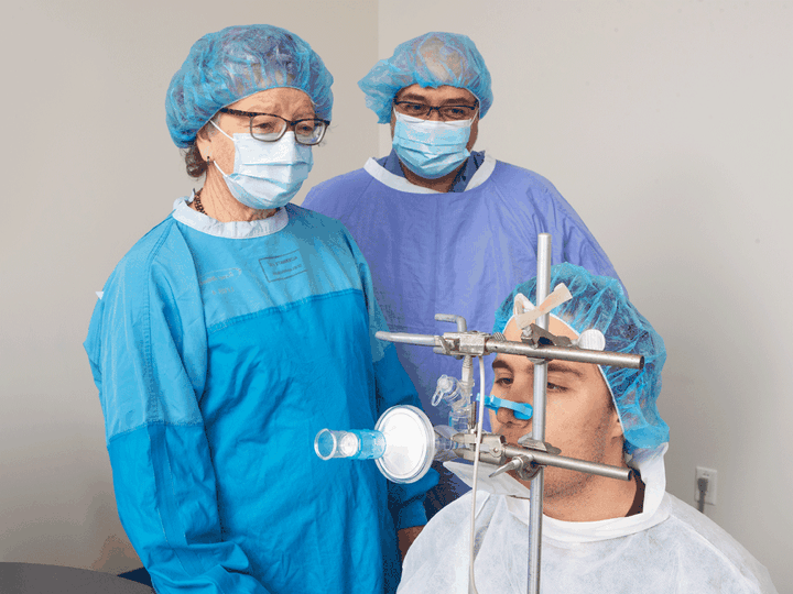  Fiona Smaill and research coordinator Emilio Aguirre demonstrate the use of the nebulizer with a volunteer.