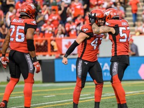 Calgary Stampeders Fraser Sopik, Riley Jones and Dagogo Maxwell celebrate during a game against the Hamilton Tiger-Cats at McMahon Stadium in Calgary on Sept. 14, 2019.