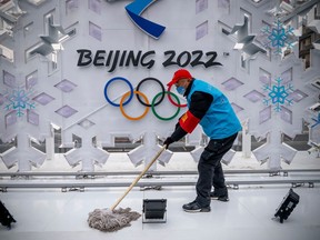 A volunteer cleans a sculpture about Beijing 2022 Winter Olympics on January 23, 2022 in Beijing, China