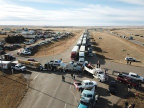A convoy of trucks and other vehicles is blocking northbound and southbound traffic on Highway 4 near the Coutts border in southern Alberta on Jan. 29, 2022.