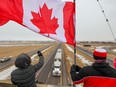 Supporters of the “freedom convoy” of truckers gathered on an overpass over the Trans-Canada Highway east of Calgary on Monday, January 24, 2022. The truckers are driving across Canada to Ottawa to protest the federal government’s COVID-19 vaccine mandate for cross-border truckers