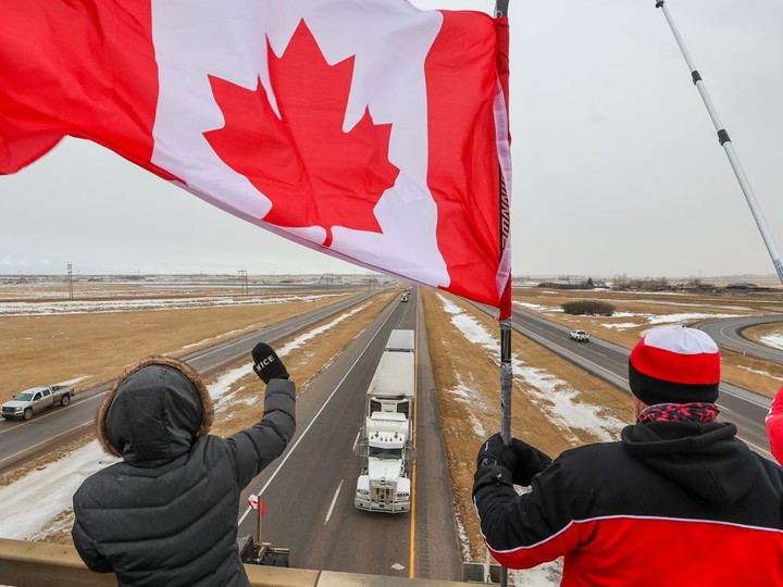  Supporters of the “freedom convoy” of truckers gathered on an overpass over the Trans-Canada Highway east of Calgary on Monday, January 24, 2022. The truckers are driving across Canada to Ottawa to protest the federal government’s COVID-19 vaccine mandate for cross-border truckers