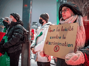 People protest in Montreal on December 15, 2021 in support of Fatemeh Anvari, a hijab-wearing teacher who was removed from her job because of Quebec's secularism law.