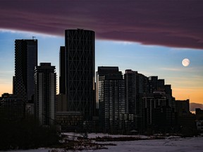 The moon sets as a chinook arch moves in over Calgary after sunrise on Thursday, Jan. 20, 2022.