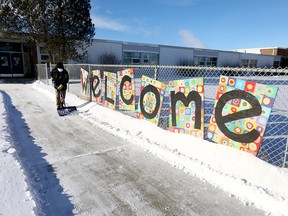 Randy Lai, facility operator of Belvedere Parkway School in Bowness, shovels the snow with still no solid answers when kids will be back to school in Calgary. Photo taken on Tuesday, January 4, 2022.