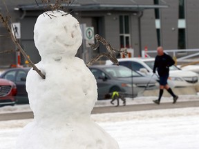 Joggers and bikers pass a snowman near Edworthy Park as another winter blast is forcasted for Calgary on Sunday, January 16, 2022.