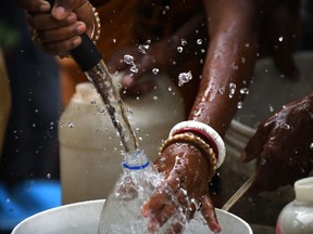 In this picture taken on June 6, 2018, an Indian resident fills jerry cans with water at a distribution point in the low-income eastern neighbourhood of Sanjay camp in New Delhi. A 2017 study by the Indian Institute of Science said that the frequency and magnitude of heatwaves accompanied with drought had increased over the past three decades. / AFP PHOTO / Dominique FAGET / TO GO WITH India-water-drought,FOCUS by Bhuvan BaggaDOMINIQUE FAGET/AFP/Getty Images