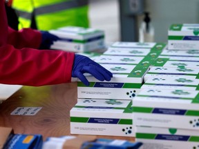 Volunteers hand out boxes of COVID-19 rapid antigen tests in northeast London on January 3, 2022. British Prime Minister Boris Johnson on Monday said that the U.K.'s state-run hospitals will face "considerable pressure" in the coming weeks due to the steep rise in virus infections. With infections rising in Alberta, the province must also prepare for the unpredictable future, writes columnist Rob Breakenridge.