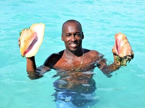 Captain Calson 'Rice' Williams shows off some of the conch catch in Turks and Caicos. Photo, Steve MacNaull