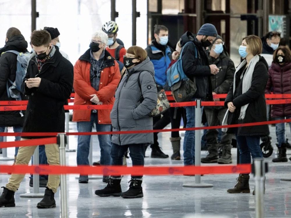  People wait in line at a COVID-19 vaccination centre inside Olympic Stadium in Montreal, on Jan. 13, 2022.