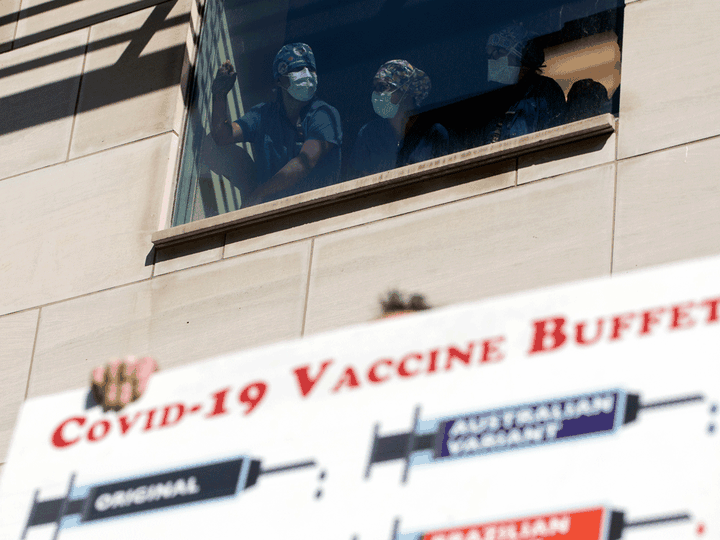  Healthcare workers watch as demonstrators gather outside Toronto General Hospital on Sept. 13, 2021, to protest against COVID-19 vaccines and restrictions.