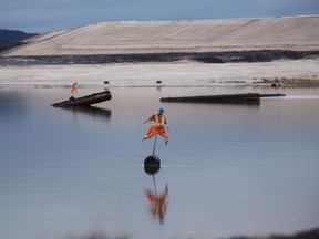 Scarecrows, used to deter birds from landing, stand in a tailings pond in the Athabasca oilsands in Alberta.