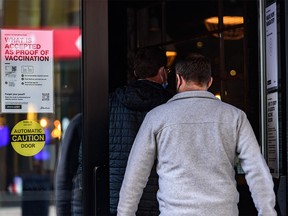 Customers enter Local on Stephen Avenue where the signs asking for vaccine proof are still up at the entrance on Wednesday, February 9, 2022 the day after Premier Jason Kenney announced the end of the Restriction Exemption Program in Alberta.