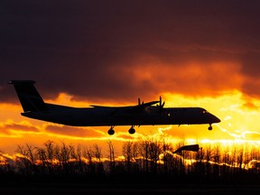 A WestJet Encore De Havilland Canada Dash 8-400 lands at Edmonton International Airport at sunset in Nisku, on Thursday, Feb. 10, 2022. The aviation industry in Canada has been coping with serious impacts from the COVID-19 pandemic since March 2020.