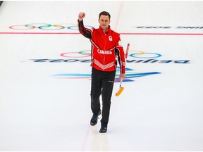 Team Canada skip Brad Gushue raise his arm after defeating the USA to win the bronze medal in men's curling at the Beijing 2022 Winter Olympics on Friday, February 18, 2022.