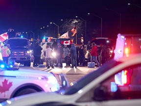 Anti-vaccine mandate protesters block an intersection near the Ambassador Bridge border crossing, in Windsor, Ontario on February 9, 2022 demanding to be let in to the main protest site at the border.