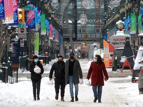 People walk along Stephen Avenue in downtown Calgary on Wednesday, Feb. 16, 2022.