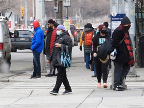 People wearing masks are seen walking downtown. Tuesday, February 15, 2022.