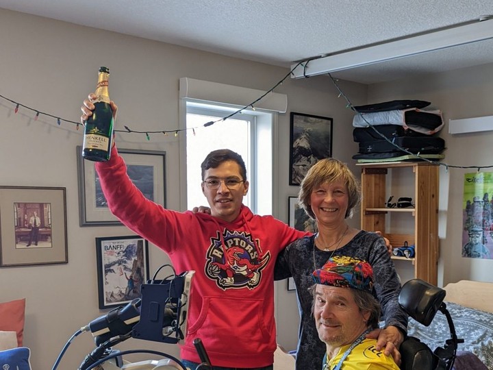  Stewart Midwinter poses for a photo after completing 40,075 km on his FES cycle. He celebrated with Jorge Errasquin, his physical therapy assistant, and Julie Muller, his spouse, coach and motivator.