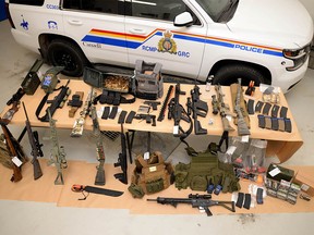 A photo provided by the RCMP on Monday, February 14, 2022 shows a large amount of weapons and ammunition seized near Coutts during a crackdown near the Canadian-US border.