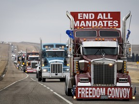 Anti-COVID-19 vaccine mandate demonstrators leave in a truck convoy after blocking the highway at the busy U.S. border crossing in Coutts, Alta., on Tuesday, Feb. 15, 2022.