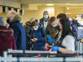 People line up to check in before their flight at Calgary International Airport (YYC) on Tuesday, Feb. 22, 2022.