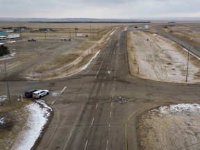 Police vehicles look out over an empty Highway 4 after anti-COVID-19 vaccine mandate demonstrators dismantled their blockade at the Coutts border crossing on Tuesday, Feb. 15, 2022.