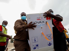 Workers carry boxes of Oxford/AstraZeneca  COVID-19 vaccines, redeployed from the Democratic Republic of Congo, at the Kotoka International Airport in Accra, Ghana, May 7, 2021.