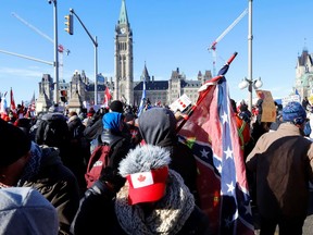 A person carries a Confederate battle flag in front of Parliament Hill as protesters gather in Ottawa, Ontario, Canada, January 29, 2022.