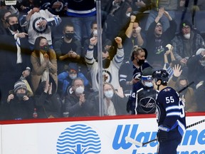 Winnipeg Jets' Mark Scheifele (55) and fans celebrate his second goal of the game against the Minnesota Wild during second period NHL action in Winnipeg on Wednesday, February 16, 2022. The Manitoba team beat Alberta's teams to full arena capacity, but fans had to wear masks.