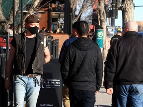 A person wearing a mask walks along 17th Ave SW. Wednesday, February 9, 2022.