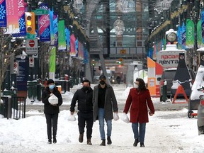 People are seen wearing a mask while walking downtown. Wednesday, February 16, 2022.