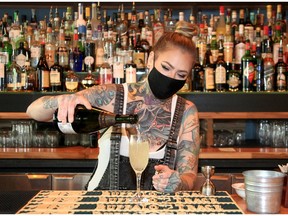 Milk Tiger staffer Rhiannon Lewis mixes up a French 75 behind the bar. Brendan Miller/Postmedia