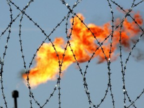 A gas flame behind a barbed wire at an oil production facility in Russia.
