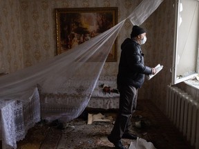 A man looks out of the window of a damaged apartment in a residential block hit by an early morning missile strike on February 25, 2022 in Kyiv, Ukraine.