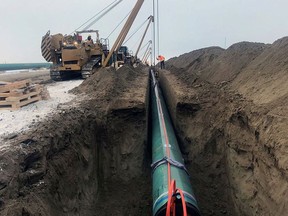To assist with global energy security, Canada should still commit itself to hydrocarbon development in a number of ways, such as treating the completion of TMX as a national priority for completion as quickly as possible, writes Dennis McConaghy. Here, pipe is laid for the Trans Mountain pipeline expansion project near Edmonton in a 2019 file photo, courtesy Trans Mountain Corp.