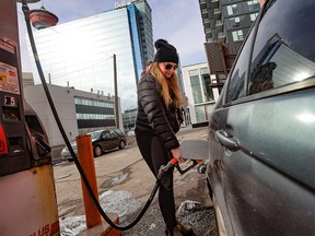 Chloe Mahon tops up her car at a Gas Plus station on Macleod Trail S.E in Calgary on Tuesday, March 7, 2022. Alberta has announced they are dropping the provincial sales tax on fuel to help consumers with surging prices.