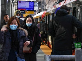 Transit riders walk in a CTrain station in downtown Calgary on Wednesday, March 9, 2022.