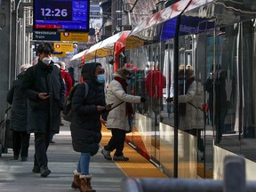 Transit riders walk into a CTrain station in downtown Calgary on Wednesday, March 9, 2022.