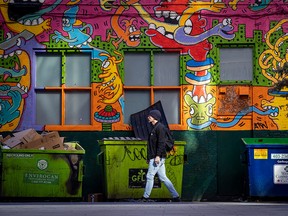 Artistic Alley — A man walks past the colourful murals that add some beauty to a back alley between 1st and 2nd Streets S.W. in downtown Calgary on Tuesday, March 15, 2022.