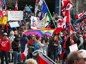 Anti-Mandats-Demonstranten gehen am Samstag, den 19. März 2022, zum Rathaus von Calgary. Die Demonstranten trafen sich im Central Memorial Park und gingen dann auf den Bürgersteigen zum Rathaus.