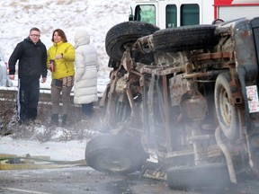 A Ford F150 lies on its side after a fatal collision on eastbound Glenmore Trail west of Deerfoot Trail on Saturday morning February 8, 2014.