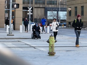 People walk downtown, some wearing a mask, others without. The province is scrapping a number of health measures that have been in place. March 1, 2022.