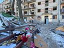 Municipal workers and volunteers remove debris from a damaged residential building, as Russia's attack on Ukraine continues, in Kharkiv on March 21, 2022.  