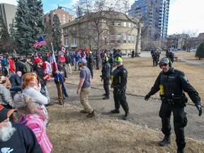 Calgary police clean up Central Memorial Park following rallies by anti-warrant protesters and counter-protesters on Saturday, March 19, 2022.