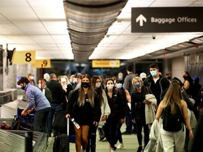 Travellers wearing protective face masks to prevent the spread of the coronavirus disease (COVID-19) reclaim their luggage at the airport in Denver, Colorado, U.S., November 24, 2020.