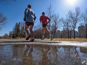 Two joggers enjoy a run along the pathway on Memorial Drive on Tuesday, March 29, 2022.