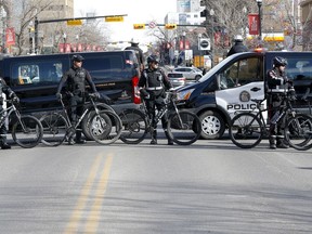 Police vehicles and bicycles block the street during a protest and counter-protest March 12 in Calgary's Beltline area.
