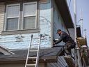 A worker with Risling Exteriors replaces vinyl siding damaged by a hail storm with fiber cement siding on a home in Skyview on Monday, April 18, 2022. Fiber cement siding is more resistant to hail damage and fire.